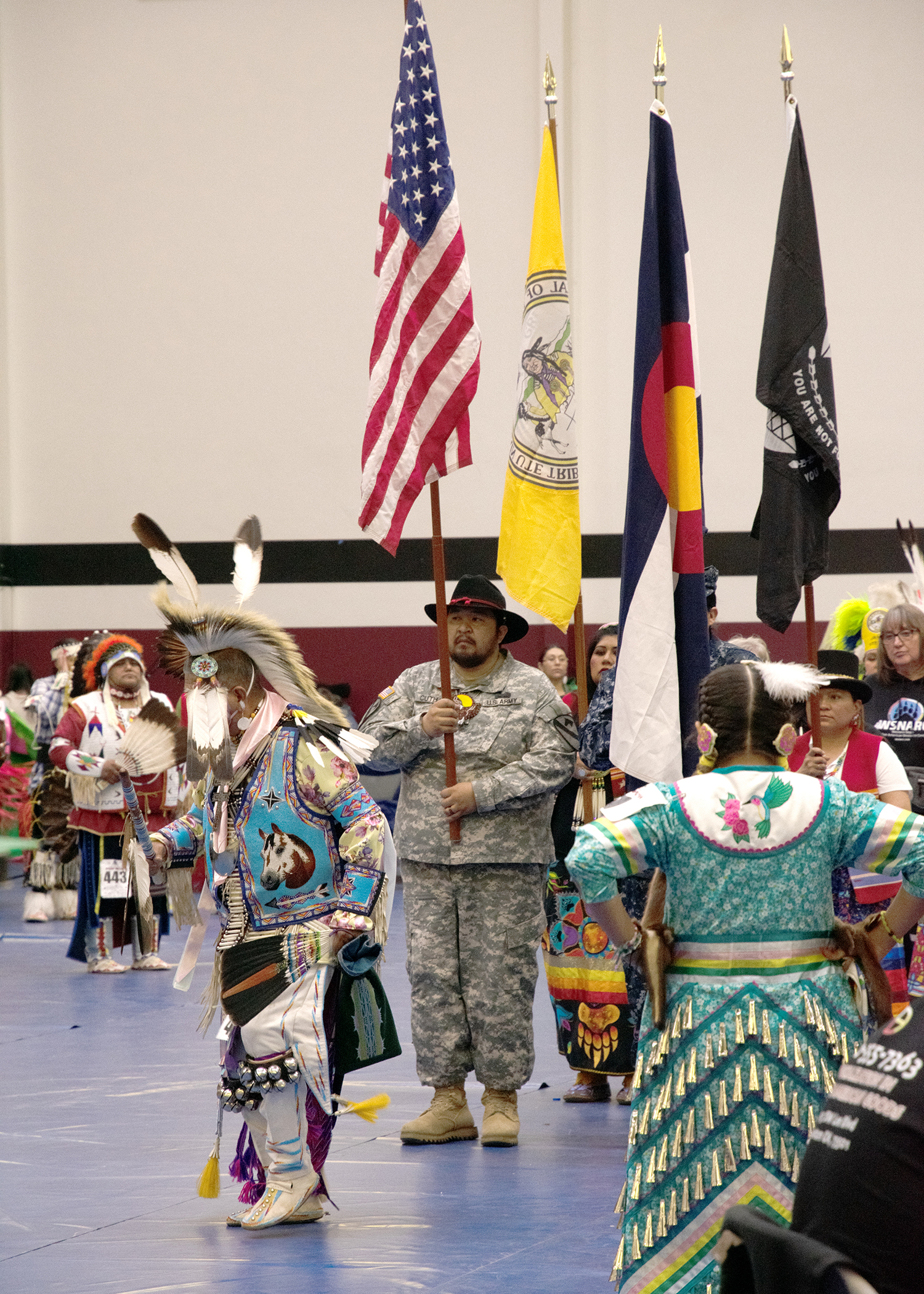 Participants carrying flags at the Grand Mesa Pow-Wow
