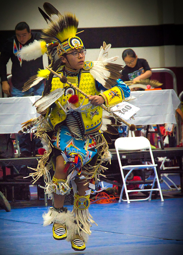 Young dancer in traditional yellow and blue regalia
