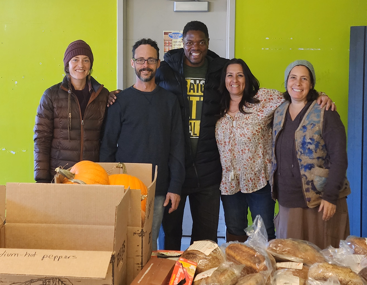 Group posing with Thanksgiving food donations