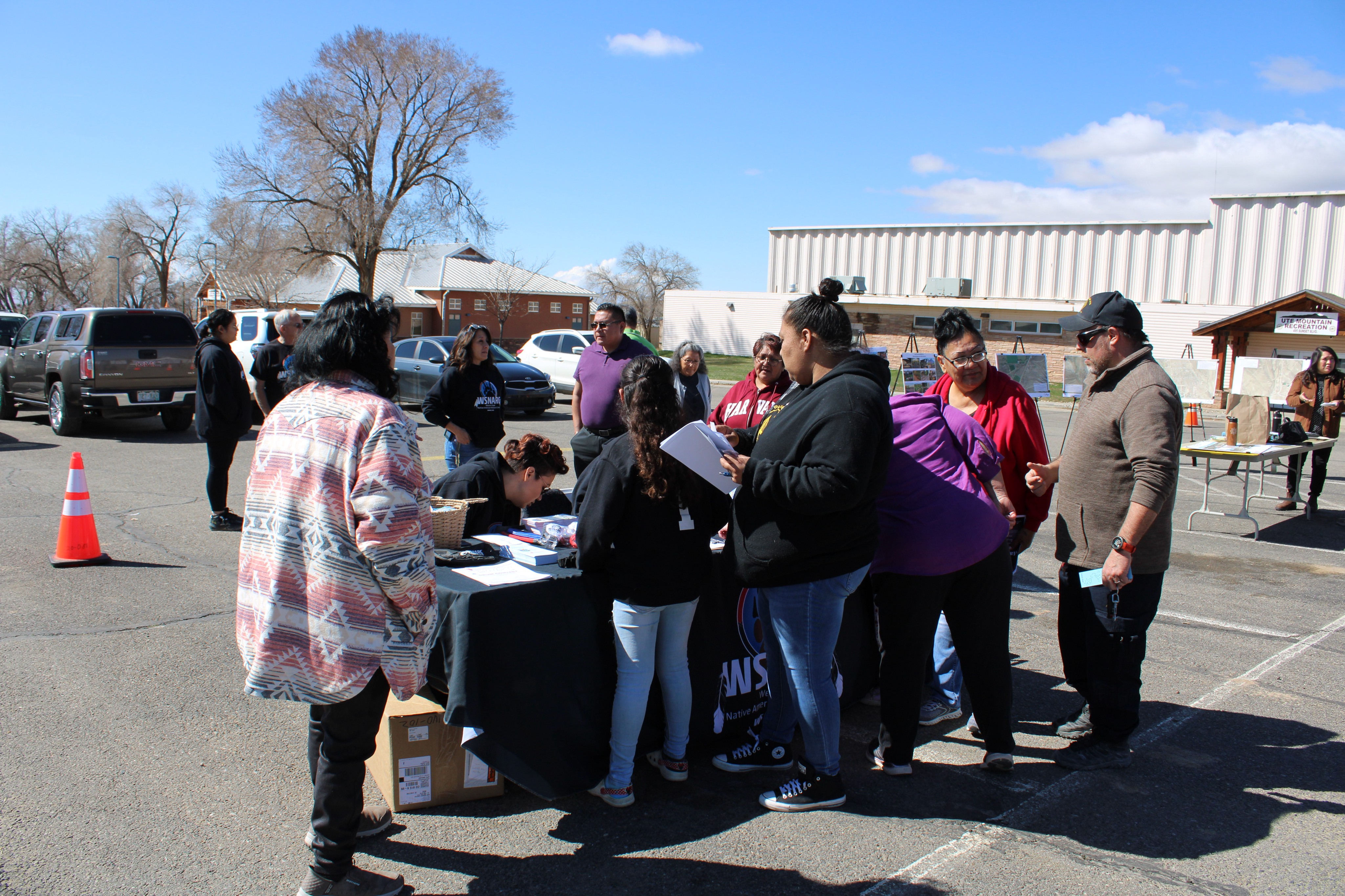 People gathered around a table at outdoor event